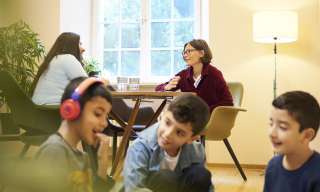 Während einer Elternberatung spielen drei Jungs am Boden.