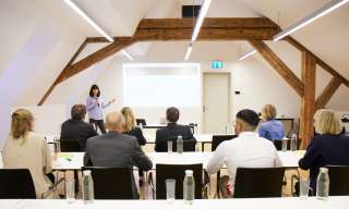 Menschen in Tagungsraum die eine Sitzung haben oder einen Vortrag hören
