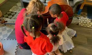 Kinder betrachten einen Kontrabass, der seitlich auf dem Boden liegt.